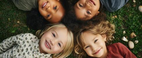The joyful children lying together on grass sharing smiles and laughter. photo
