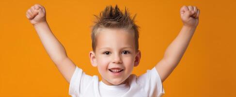 The joyful child celebrating with raised arms against a bright background. photo