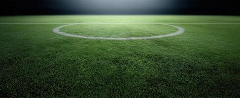 The illuminated soccer field under spotlights with detailed turf and central circle photo