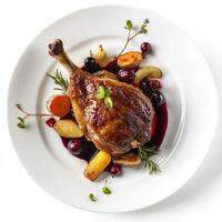 An image of a plate of duck confit, served with roasted root vegetables and a cherry sauce, photo