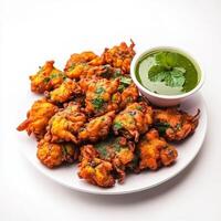 A plate of vegetable pakoras, with crispy fritters made from mixed vegetables and gram flour, served photo