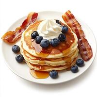 A plate of fluffy pancakes, topped with fresh blueberries, a drizzle of maple syrup, and a dollop of photo