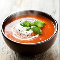 A steaming bowl of creamy tomato soup, topped with a swirl of fresh cream and a sprig of aromatic photo