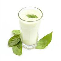 A glass of milk with basil leaves on top photo