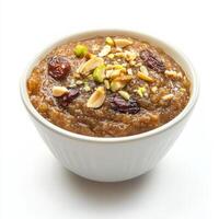 A bowl of dates halwa, with a sweet pudding made from dates, milk, and nuts, isolated on clean white background. photo
