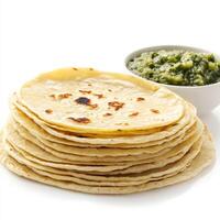A close-up of a stack of fluffy corn tortillas, freshly made and served warm, perfect for tacos or enchiladas, with a side of salsa verde. isolated on clean white background. photo