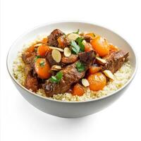 An artistic arrangement of a bowl of Moroccan tagine, featuring tender lamb, apricots, and almonds, served with couscous. The Moroccan tagine, with its sweet and savory flavors and aromatic spices, photo