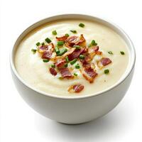 A detailed image of a bowl of creamy cauliflower soup, topped with crispy bacon bits and chives, presented on a pure white background. The cauliflower soup, with its smooth, velvety texture and rich photo