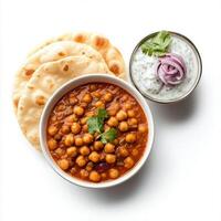 A bowl of chana masala, with chickpeas cooked in a spicy tomato and onion sauce, served with bhatura bread and a side of raita, isolated on clean white background. photo