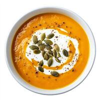 A bowl of creamy carrot and ginger soup, with roasted carrots, ginger, garlic, and vegetable broth, blended until smooth and creamy, topped with a swirl of coconut cream and toasted pumpkin seeds, photo
