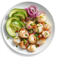 A plate of scallop aguachile, scallops marinated in lime juice, with cucumbers, red onions, and serrano peppers, served cold with avocado slices, isolated on clean white background. photo