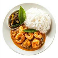 A plate of prawn curry, with prawns cooked in a tangy coconut and tamarind sauce, served with rice and a side of vegetable olan, garnished with curry leaves, isolated on clean white background. photo