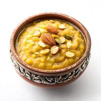 A bowl of moong dal halwa, with a sweet pudding made from mung beans, milk, and sugar, garnished with nuts, cardamom, and silver varak, arranged in a traditional bowl, isolated on clean white photo