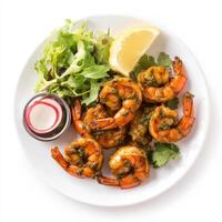 A plate of prawn cafreal, with prawns marinated in a green masala and fried until crispy, served with salad and lemon wedges, isolated on clean white background. photo