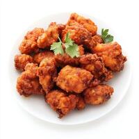 A plate of chicken 65, with crispy chicken pieces marinated in spices and deep-fried, isolated on clean white background. photo
