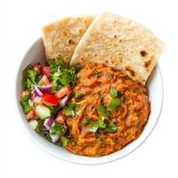 A bowl of baingan bharta, with roasted eggplant mashed and cooked with tomatoes, onions, and spices, served with roti and a side of salad, isolated on clean white background. photo