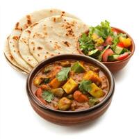 A bowl of mixed vegetable curry, with a variety of vegetables cooked in a flavorful coconut and tomato sauce, served with roti and a side of salad, arranged in a traditional bowl, isolated on clean photo
