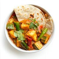 A bowl of mixed vegetable curry, with a variety of vegetables cooked in a flavorful coconut and tomato sauce, served with roti, isolated on clean white background. photo