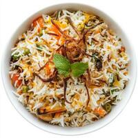 A bowl of vegetable biryani, with a mix of colorful vegetables, basmati rice, and aromatic spices, garnished with fried onions, mint leaves, and a sprinkle of saffron, isolated on clean white photo