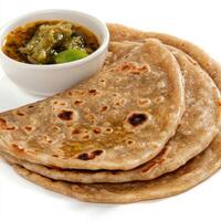 Three flatbreads with a small bowl of sauce photo