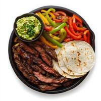 A sizzling fajita platter, with strips of marinated steak, bell peppers, and onions, grilled to perfection and served with warm flour tortillas and a side of guacamole, presented on a cast iron photo