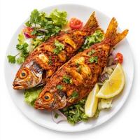 A plate of fish recheado, with fish stuffed with a spicy masala and fried until crispy, served with salad and lemon wedges, garnished with cilantro, isolated on clean white background. photo