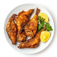 Fried fish with lemon and parsley on white plate photo