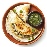 A plate of cheesy quesadillas, filled with melted Oaxaca cheese, mushrooms, and epazote, grilled until golden brown and served with a side of salsa verde, arranged on a terracotta plate. isolated on photo