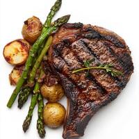 A close-up of a perfectly grilled ribeye steak, its charred surface revealing a juicy and tender interior, resting on a bed of roasted potatoes and asparagus. The ribeye steak, with its rich flavor photo