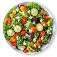 An aerial view of a colorful salad, composed of mixed greens, cherry tomatoes, cucumber slices, and crumbled feta cheese. The greens, a lush medley of textures, provide a crisp base for the sweet photo