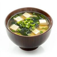 A bowl of steaming miso soup with soft tofu cubes, seaweed, and sliced green onions, served in a traditional Japanese lacquer bowl. A comforting and umami-rich dish. Isolated on clean white background photo