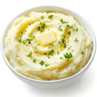 A bowl of creamy mashed potatoes with a swirl of melted butter on top, garnished with freshly chopped parsley. Smooth, fluffy, and full of comforting flavor. Isolated on clean white background photo