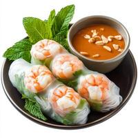 A plate of fresh spring rolls wrapped in rice paper, filled with shrimp, vermicelli noodles, lettuce, and mint, served with a peanut dipping sauce. A healthy and refreshing appetizer. Isolated on photo