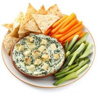 A plate of creamy spinach and artichoke dip, baked to a golden brown and served with crispy pita chips and fresh vegetable sticks. A perfect party appetizer. Isolated on clean white background photo