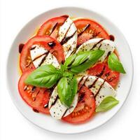 A refreshing Caprese salad with thick slices of ripe tomatoes, fresh mozzarella, and basil leaves, drizzled with extra virgin olive oil and balsamic glaze. Isolated on clean white background photo