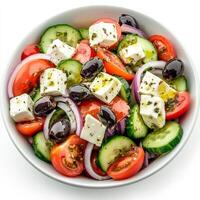 A fresh Greek salad featuring crisp cucumbers, ripe tomatoes, red onions, black olives, and chunks of feta cheese. The ingredients are drizzled with olive oil and sprinkled with oregano, creating a photo