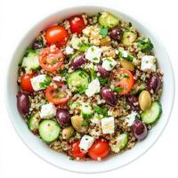 A colorful bowl of Mediterranean quinoa salad with cherry tomatoes, cucumbers, Kalamata olives, feta cheese, and a lemon vinaigrette dressing. A healthy and refreshing dish. Isolated on clean white photo