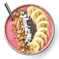 A colorful smoothie bowl made with blended tropical fruits, topped with granola, sliced bananas, chia seeds, and coconut flakes. A nutritious and visually appealing breakfast. Isolated on clean white photo
