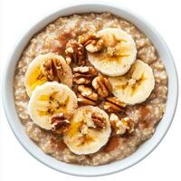 A bowl of hearty oatmeal topped with sliced bananas, chopped walnuts, a drizzle of honey, and a sprinkle of cinnamon. A wholesome and nourishing breakfast. Isolated on clean white background photo