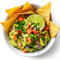 A freshly prepared guacamole bowl made with mashed avocados, diced tomatoes, red onions, lime juice, and cilantro, served with crispy tortilla chips. Isolated on clean white background photo