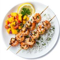 A plate of grilled shrimp skewers, seasoned with garlic, lemon, and herbs, served with a side of coconut rice and a mango salsa. A light and tropical seafood dish. Isolated on clean white background photo