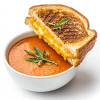 A golden-brown grilled cheese sandwich with melted cheddar oozing between two crispy slices of buttered bread. Served alongside a bowl of tomato soup for the ultimate cozy meal. Isolated on clean photo