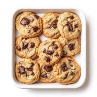A tray of freshly baked chocolate chip cookies, slightly crisp on the edges with gooey melted chocolate chunks inside. The cookies are arranged in a cozy, homemade style. Isolated on clean white photo