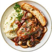 A plate of tender coq au vin, chicken braised in red wine with mushrooms, pearl onions, and bacon, served with creamy mashed potatoes and a side of crusty baguette to soak up the flavorful sauce, photo