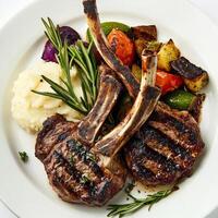 Grilled lamb chops with mashed potatoes and vegetables photo
