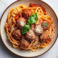A plate of spaghetti alla chitarra con polpette, featuring square-shaped spaghetti made on a guitar-like tool, tossed with a simple yet flavorful tomato sauce, and served with tender meatballs made photo