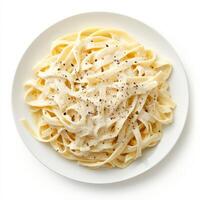 A plate of fresh fettuccine alfredo, with wide, flat noodles tossed in a creamy sauce made with butter, parmesan cheese, and heavy cream, garnished with freshly grated parmesan cheese and a sprinkle of black pepper, isolated on clean white background. photo