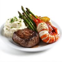 A gourmet surf and turf platter featuring a perfectly seared filet mignon and a buttery lobster tail, served with roasted garlic mashed potatoes and steamed asparagus. A luxurious meal. Isolated on clean white background photo