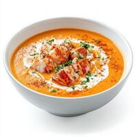 A bowl of rich and creamy lobster bisque with chunks of fresh lobster meat, garnished with a swirl of heavy cream and a sprinkle of paprika. A luxurious seafood soup. Isolated on clean white background photo