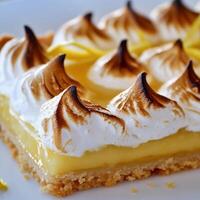A square piece of lemon meringue pie with meringue photo